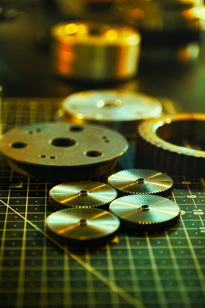 High-detail close-up of metal gears arranged on a black grid surface with soft lighting.